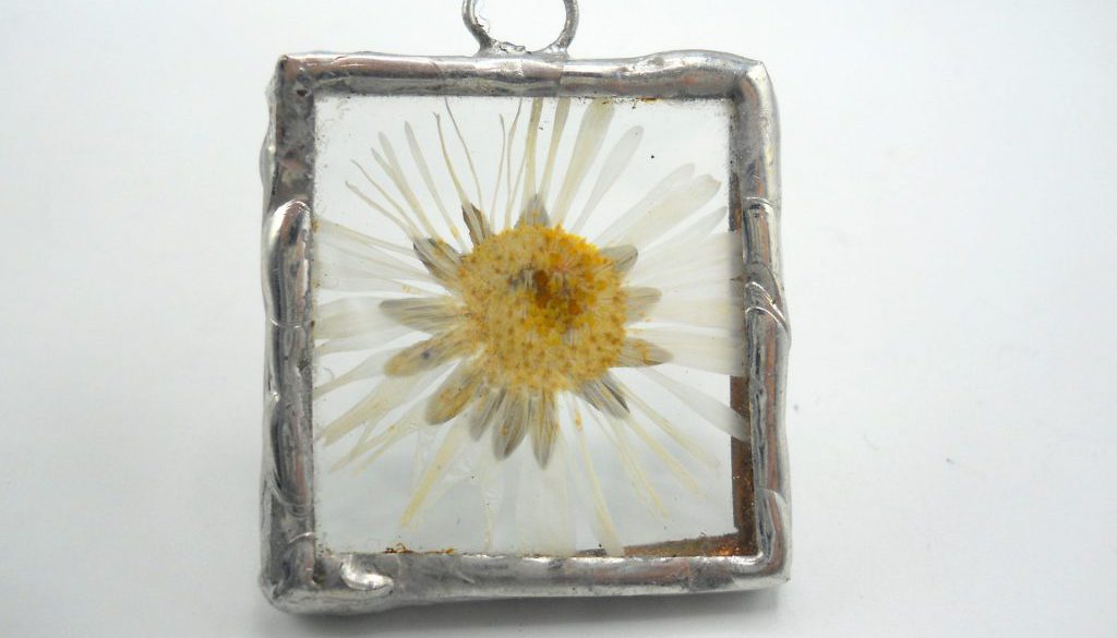 ciondolo composto da fiorellini di campo veri, incastonati tra vetri trasparenti in lega argento con tecnica Tiffany